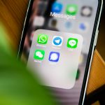 Smartphone affichant des applications de messagerie pour illustrer un problème de notifications WhatsApp